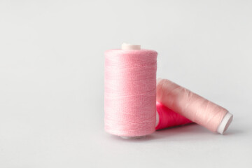 Multicolored sewing thread spools on light background