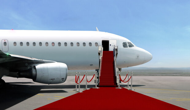 Airplane with red carpet on airport taxiway under bright blue sky foto de  Stock | Adobe Stock