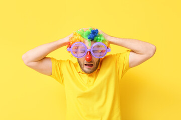 Funny young man in disguise on yellow background. April fools' day celebration