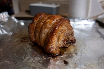 Close up, selective focus on a juicy, pork chashu roast resting on tin foil after being cooked