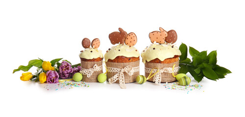 Delicious Easter cakes decorated with cookies and flowers on white background