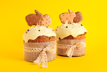 Delicious Easter cakes decorated with cookies on yellow background