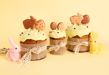 Delicious Easter cakes decorated with cookies on beige background