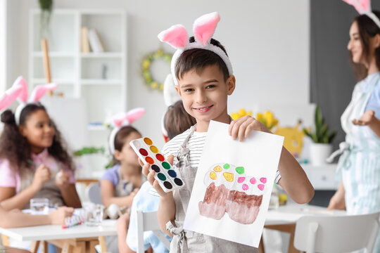 Cute boy with picture of Easter cakes painted during master-class in art