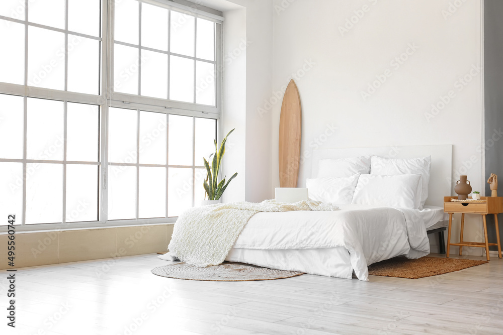 Poster Interior of modern bedroom with wooden surfboard and table