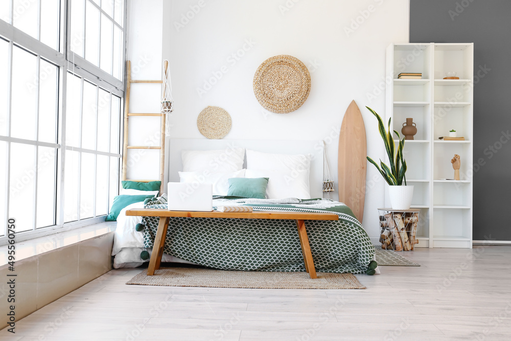 Poster interior of light bedroom with wooden surfboard, bench and shelving unit