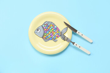 Plate with paper fish and cutlery on color background. April Fools Day celebration