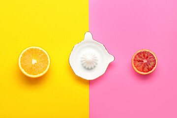Ceramic juicer, cut orange and grapefruit on color background