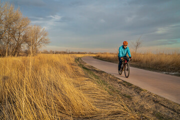 early spring afternoon on a biking trail with a senior cyclist riding a gravel bike - Poudre River Trail in Fort Collins, Colorado © MarekPhotoDesign.com