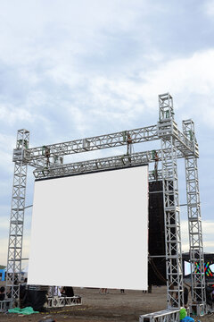 Large blank open-air outdoor white screen for public event such as presentation, concert, cinema, conference, movie, festival, show. Mock up for advertisement