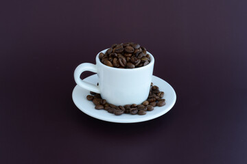 Roasted Coffee beans in coffee cup on a brown background