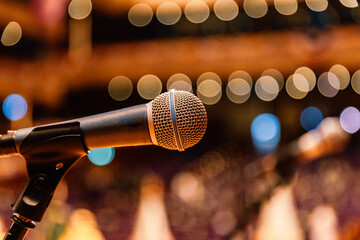 Close up of microphone on the theater stage in concert hall and blurred lights background
