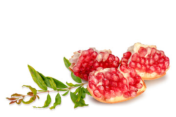 Fresh juicy pomegranate in cut pieces with green leaves isolated on white background. Clipping path.