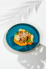 Beef cheeks with gravy on vegetables mashed. Main course - srew beef with pumpkin mash and crispy onion rings. Modern food. Fusion cuisine.