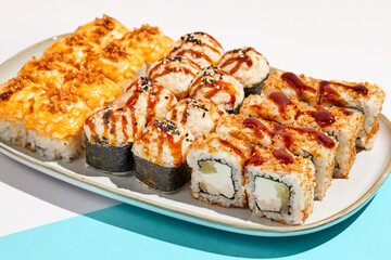 Set of hot maki sushi on ceramic dishware. Baked sushi set in minimal style. Tempura rolls in modern concept. Japanese menu in modern style.