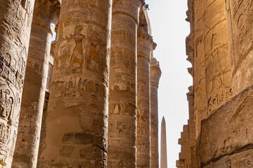 Colonnade in the hypostyle hall of the Karnak Temple in Luxor. A narrow passage between rows of...