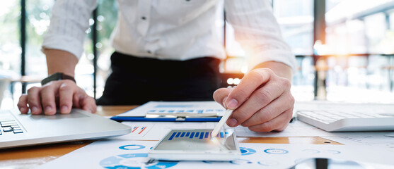 Businessman accountant analyze business report graph and finance chart at corporate office. Using...