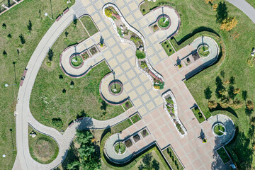 Obraz premium recreation place in summer park with footpaths, green lawn and trees. aerial drone photo.