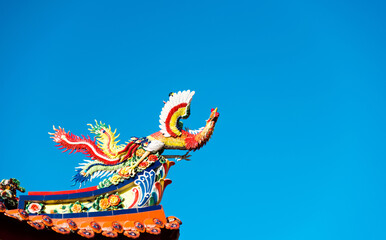 Fototapeta na wymiar Chinese style phoenix bird at the roof of temple