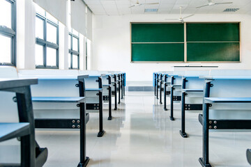 Bright university classroom with blue desks and chalkboard