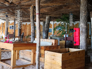 Sal Rei, Cape Verde - February 14th 2019: outdoor bar view in Africa. Wooden tables, traditional decor elements, cozy view and hot weather. Selective focus on the details, blurred background.