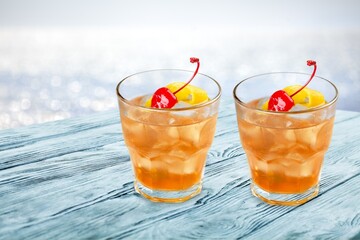 Tasty cocktail drinks with blur beach and sunset in background