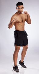 Follow through with determination. Shot of a young man practicing his punches against a studio background.