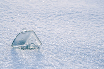 beautiful little glass, crystal house on background of white snow. Concept of real estate investment. Take out mortgage. Real estate business. Copy space