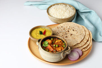 vegetarian Indian thali or Indian home food with lentil dal, cauliflower curry, roti or Indian flat...