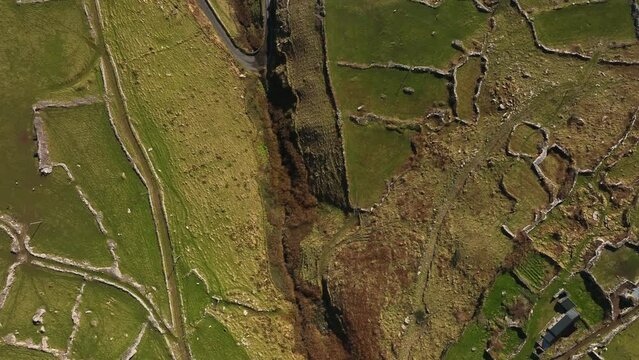 Ventry, Kerry, Ireland, March 2022. Drone in Bird's-eye view pushes across rugged farmland from the north towards Dingle Bay above Glanfahan on the Wild Atlantic Way.