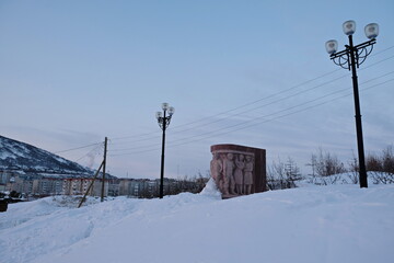 A monument in honor of the builders of the city, covered with a large layer of snow.
