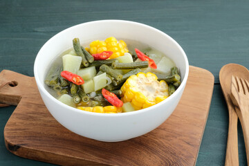 Sayur asam, sayur asem or tamarind soup is a popular traditional Indonesian soup. Common ingredients are chayote, long beans and corn with the addition of tamarind or bilimbi. Served in white bowl.
