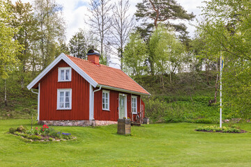 Red small idyllic cottage with a beautiful garden