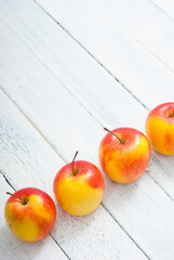 apple fruits in a row, white wooden table background
