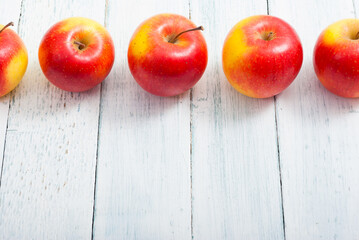 apple fruits in a row, white wooden table background