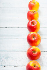 apple fruits in a row, white wooden table background
