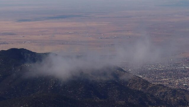 Albuquerque visible in the distance as clods gently drift across the tops of the Sandia mountains.