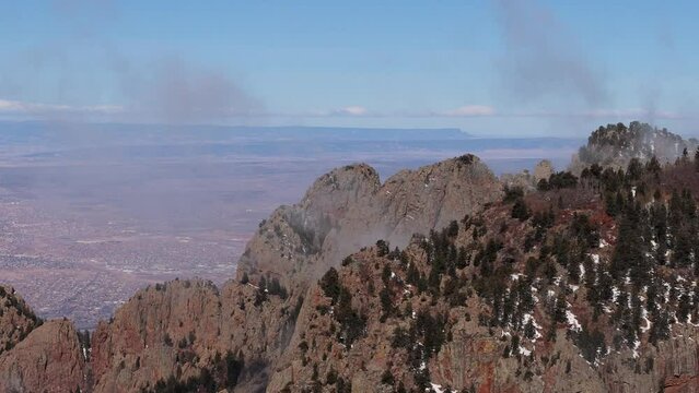 High altitude clouds drift gently above Albuquerque on the tops of the Sandia mountains.