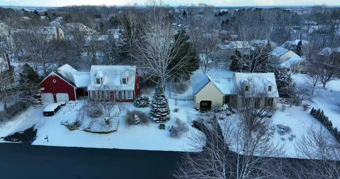 Truck shot of Cape Cod homes covered in winter snow. Residential suburban development.