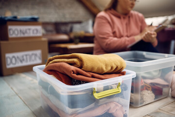 Donation box with clothes with a volunteer in background.