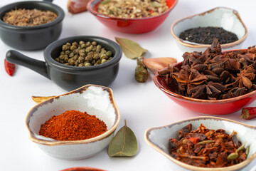 Bowls with various spices on white background