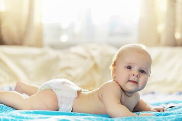 The little baby is lying on the crib. Newborn.