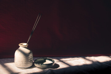 Light and shadows cast on ceramic incense holder showing the concept of mindfulness, tranquility and life balance