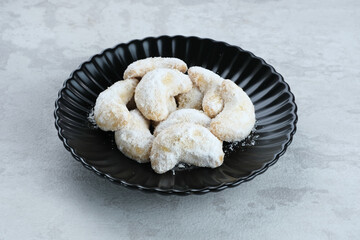 Kue Putri Salju or Snow White Cookies with crescent shaped. Made from flour, sugar and butter coated with powdered sugar. Popular to celebrate Eid al Fitr. Selective focus image.
