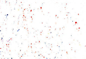 Drops of red and blue paint on a white background.