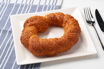 Freshly baked sesame bagel on white table