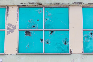 The windows of the house were shot with a gun.