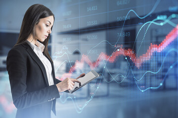 Attractive young white businesswoman using tablet with abstract red forex chart index on blurry office interior background. Digital data, company and crisis concept. Double exposure.