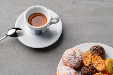 Cup of espresso and cookies on a gray table