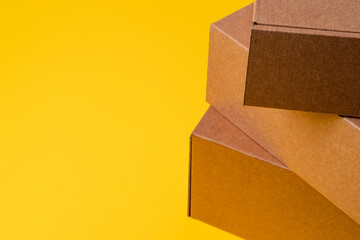 Beige cardboard boxes on yellow background, close up